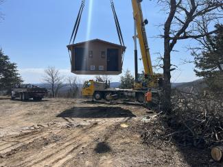 a toilet on a crane being put into place at Caney Day Use