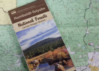 A map of Humboldt-Toiyabe National Forest, featuring a landscape image, is placed on top of a detailed regional map.