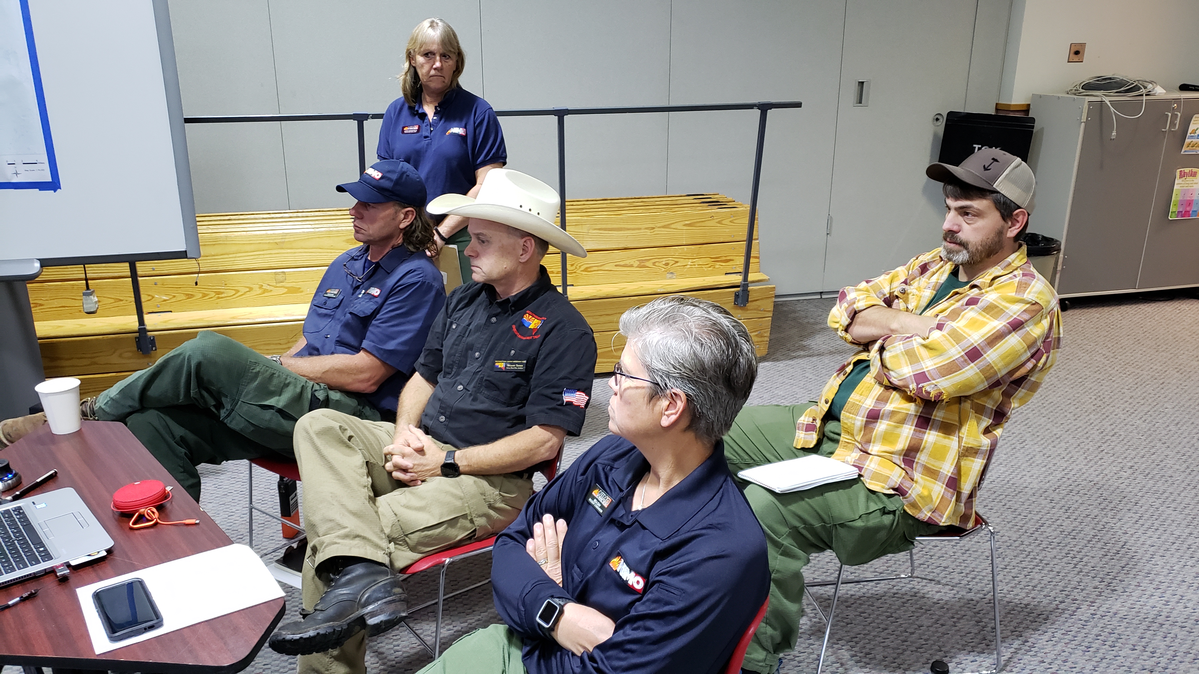 People in a group watching a screen during a fire close out