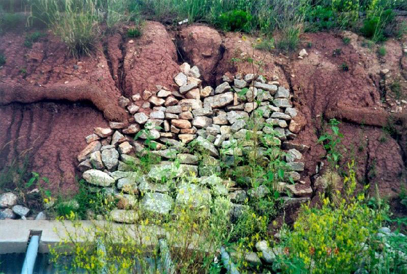 Surface water concentration from above causing erosion of backslope: attempt to harden slope.