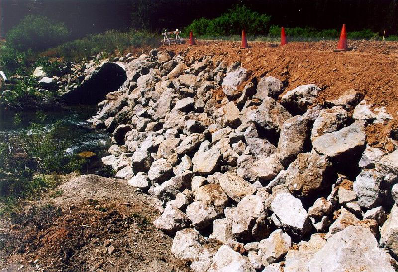Road/stream crossing fillslope armored with rip-rap to resist culvert washout.
