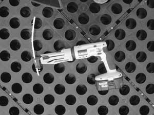 Photo of a Quick Drive automatic-feed screw gun laying on a panel of GeoBlock.