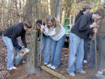 Photo of Future Farmers of America volunteer students working on a boardwalk.
