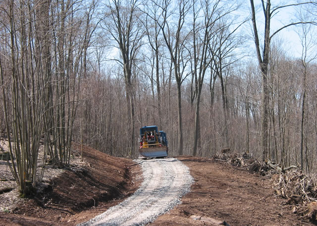 Gravel application to a newly constructed forest road to protect the road surface from erosion, and woody material from the road right-of-way positions as a windrow on the fillslope (right side of photo) to trap any sediment transported off the road. Photo by Pamela Edwards, Forest Service