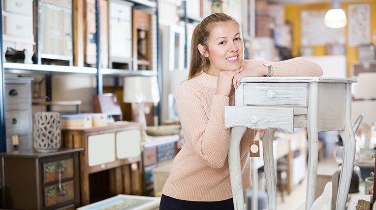 Young woman considering purchase of a wooden table.