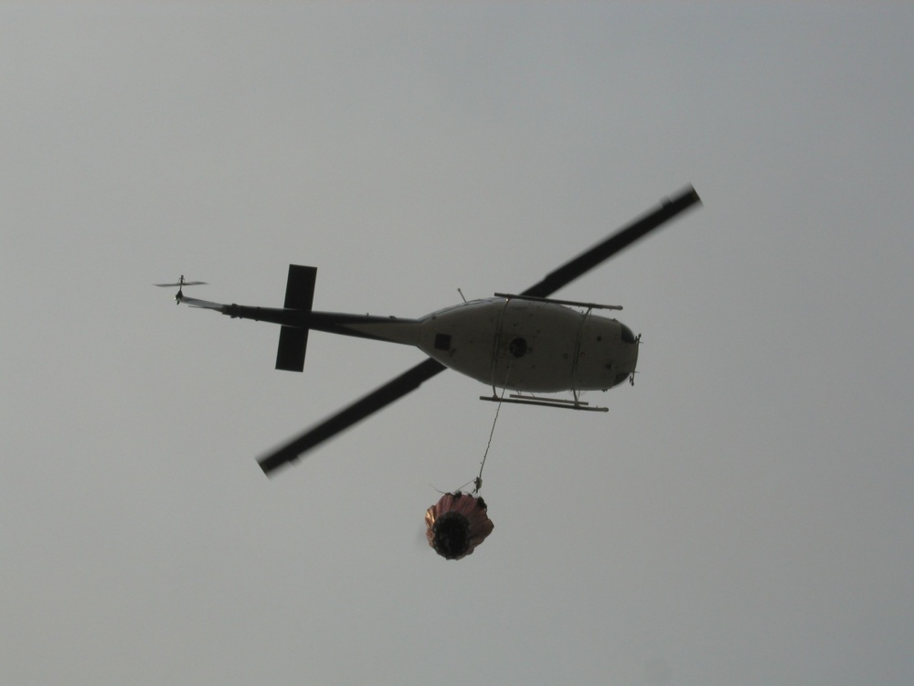 A helicopter is carrying water to the fire. A helicopter is carrying water to the fire.
