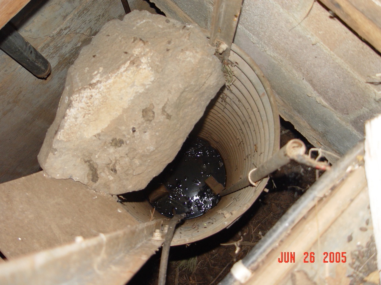 What remains of the stilling well has been filled with rocks and trash.