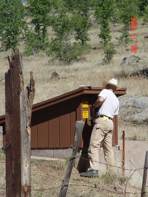 Hydrologist Boris Poff is accessing  the data logger of the Watershed 11 stream gauging station to download streamflow data of the 2006 monsoonal run-off.
