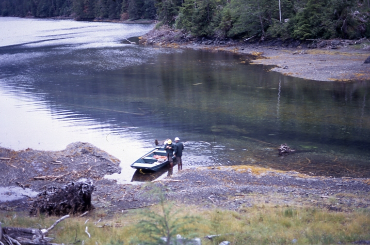 Two men at skiff at beach