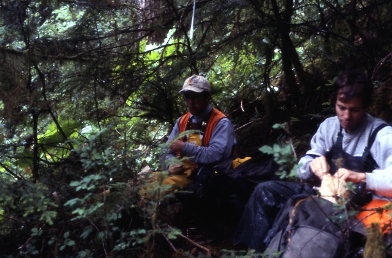 Two people in forest eating lunch