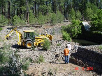 Heavy machinery is used to repair damage to the Bar M stilling pond.