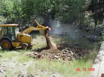 Heavy machinery is used to level the Woods Canyon stilling pond after years of streamflow had erroded the streambed.
