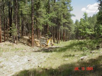 Heavy machinery is used to level the Woods Canyon stilling pond after years of streamflow had erroded the streambed.