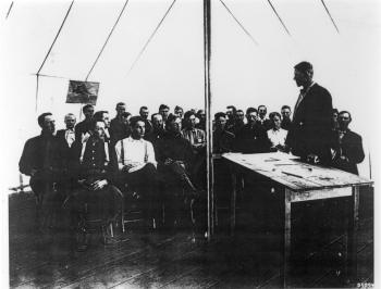 An early photo of G.A. Pearson (standing) at a meeting with other foresters