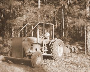 J.T. Rhodes at the wheel of a tractor used to skid logs at the Crossett Experimental Forest.