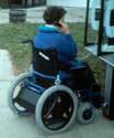 Photo of a woman using a motorized wheelchair.