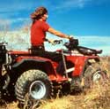 Photo of a woman riding an all-terrain vehicle.