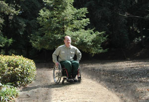 A gentleman in a wheelchair moving on a firm stable surface.
