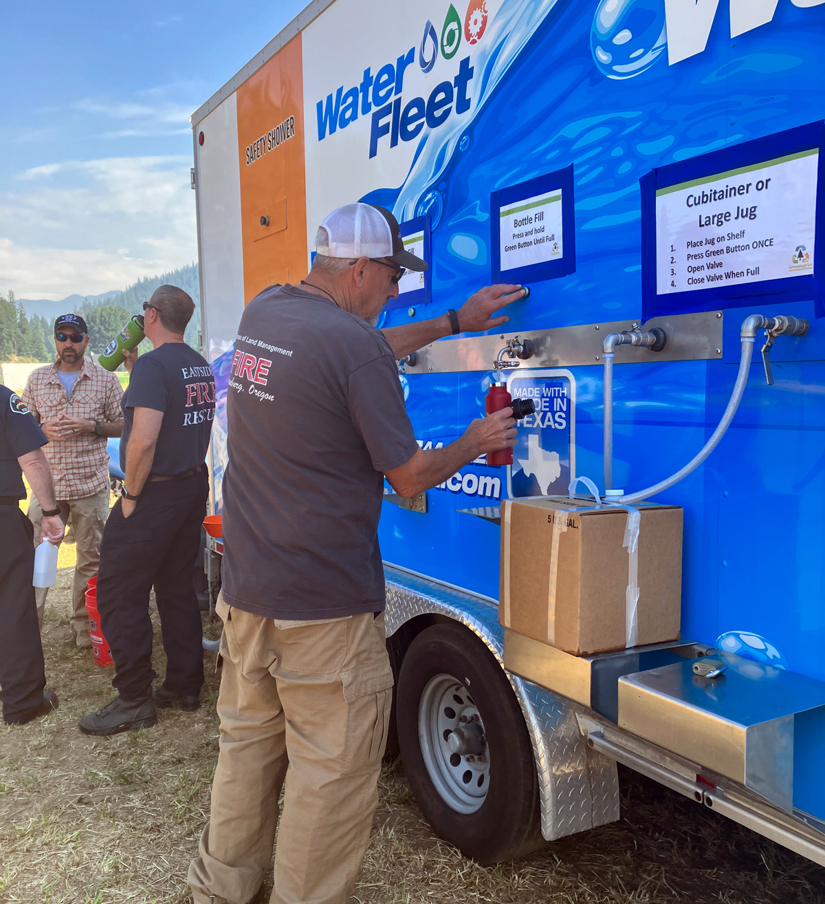 "A person filling a drinking container with filtered water from a portable water filtration system."