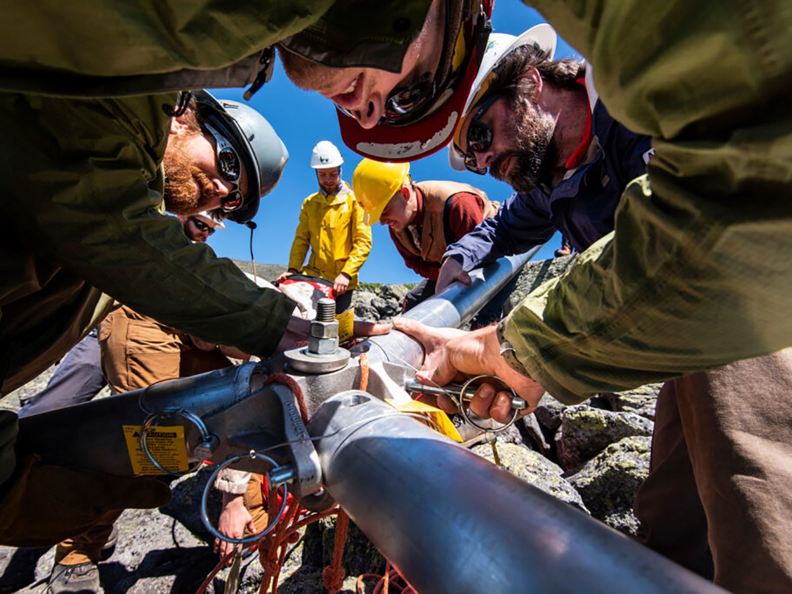 Image of trail workers installing a piece of equipment.