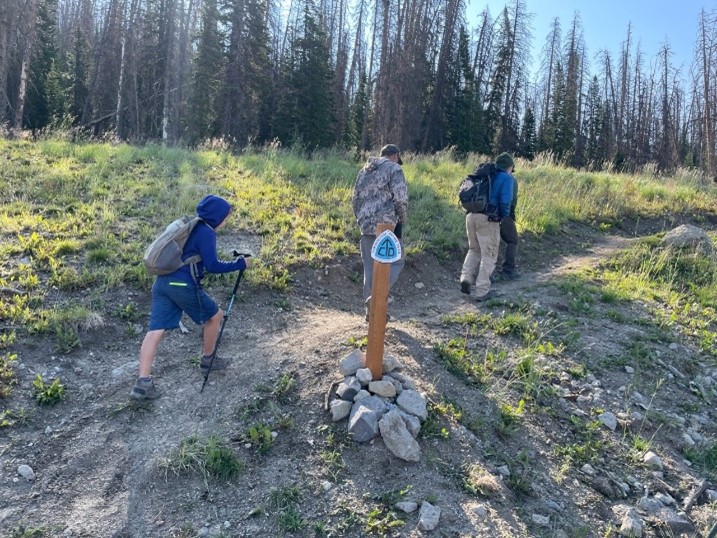 Image of people with backpacks walking on a trail.