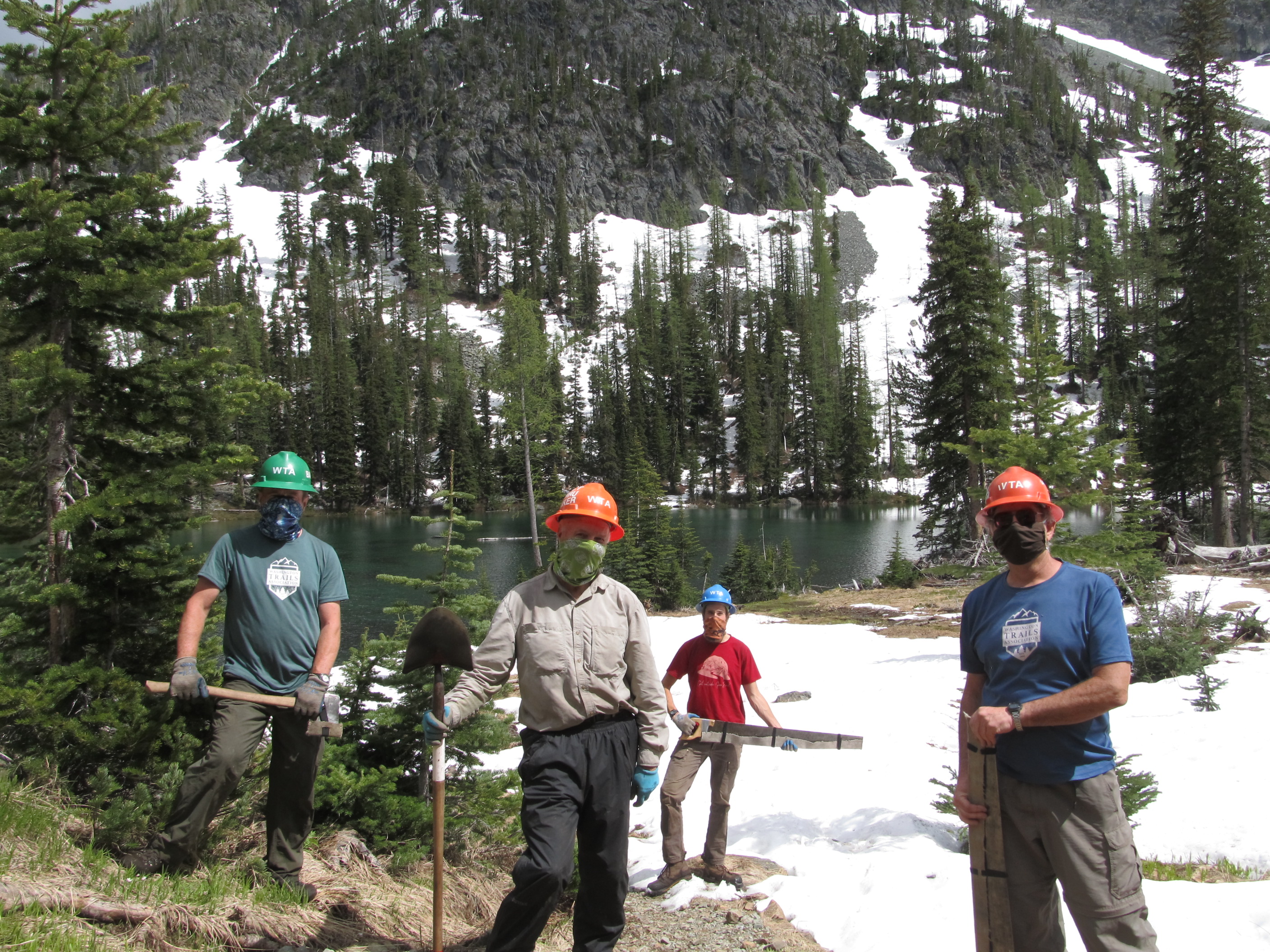 Image of trail workers standing with trail tools.
