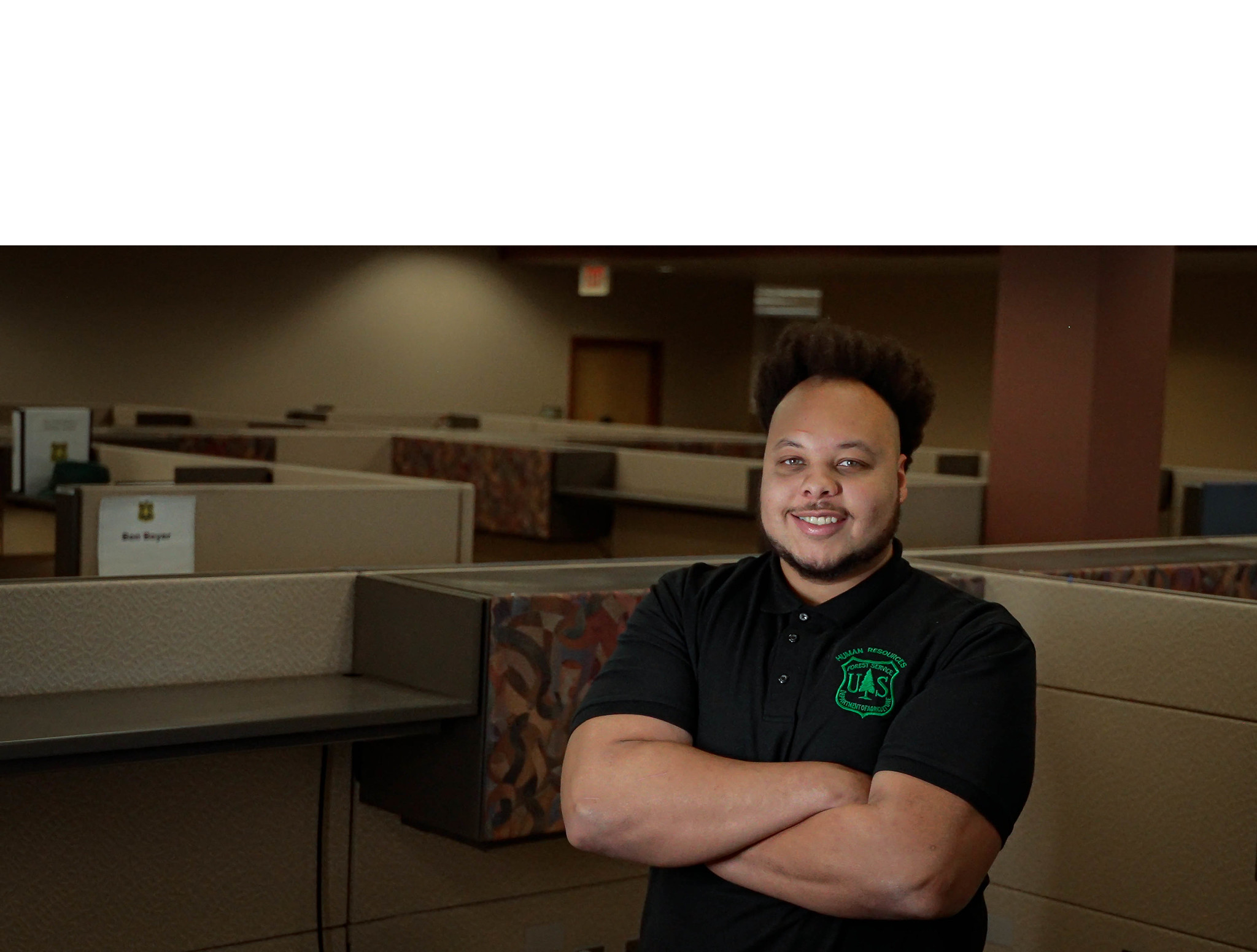 Human resources specialist standing in a work cubicle