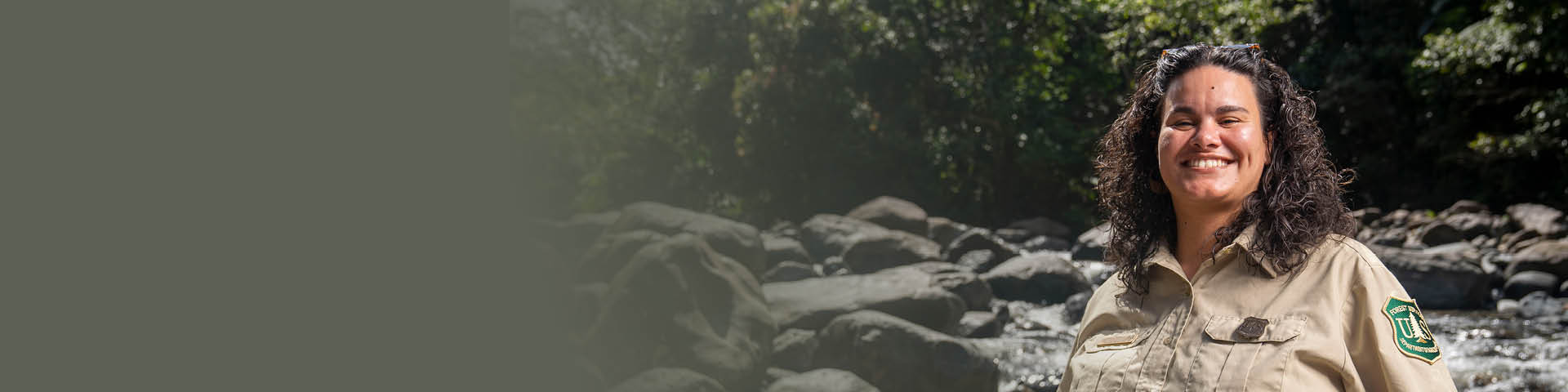 Forest Tech posing for a photo in front of a stream