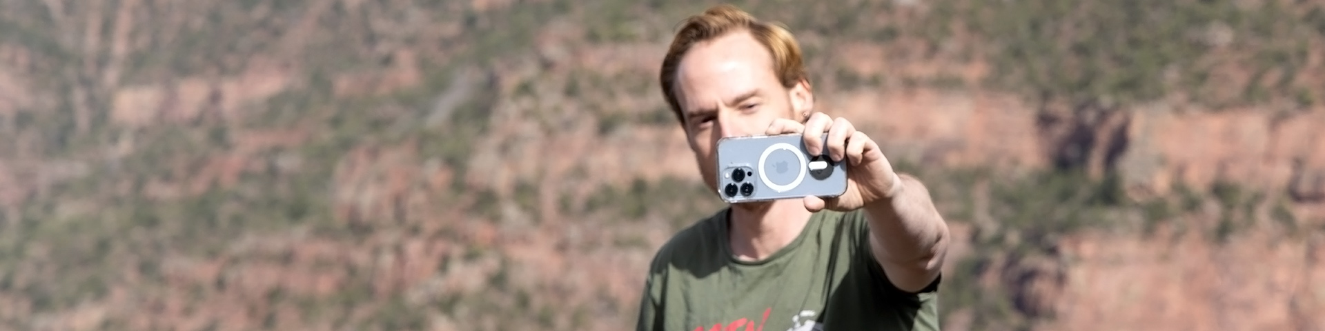 A person holding up a smartphone as if taking a selfie or video.