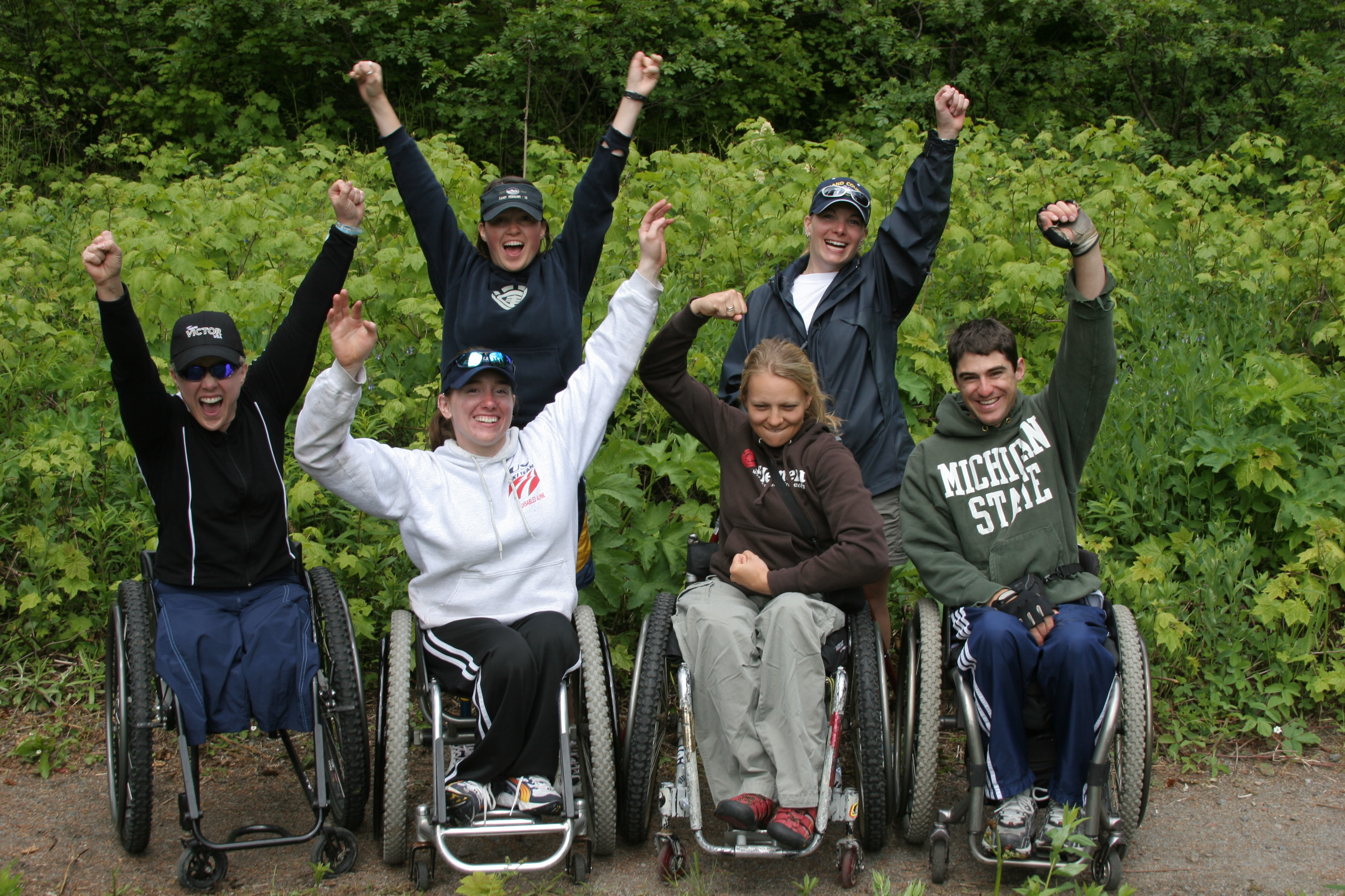 Several teenagers raise their hands in triumph