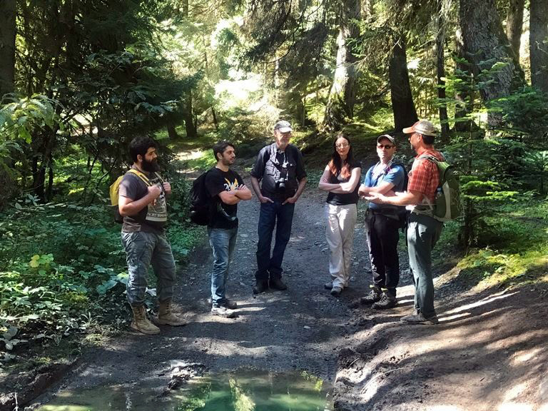 Group of people standing on a trail.