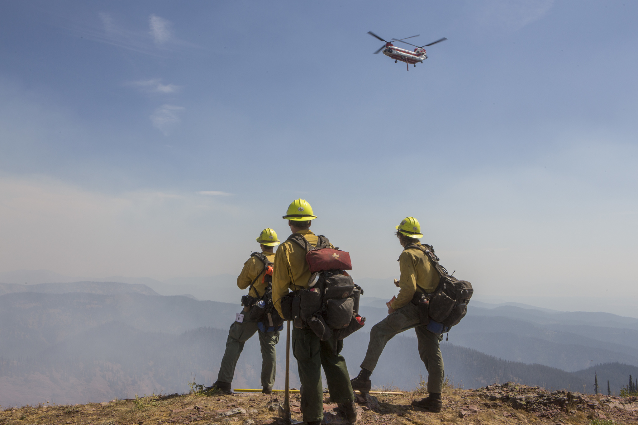 Firefighters watching helicopter on wildfire incident