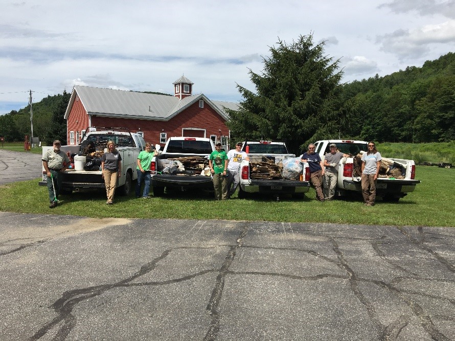 Photo: four pick-up trucks with their beds full of trash bags collected from Green Mountain National Forest