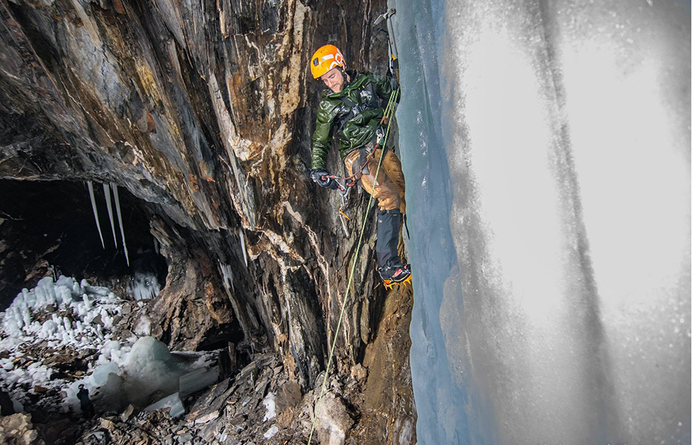 Photo: Adam DiPietro climbing cliff face.