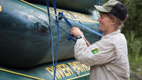 Employee ties up rafts atop one another.