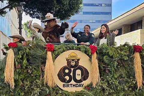 Smokey Bear poses with Forest Service employees atop a float celebrating the fire prevention icon's 80th birthday.