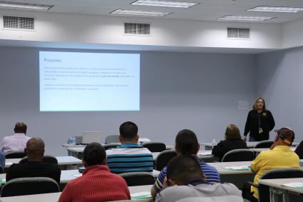 Woman using a power point, addresing a room full of people