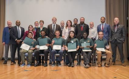 Group photo. Students and instructors on stage.