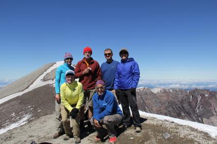 A picture of Johnny Fleming with five other fellow Forest Service colleagues posing for a picture at the top of Mt. St. Helens.