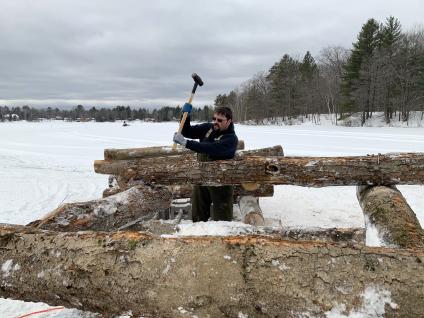 Employee swinging a hammer while constructing fish crib.