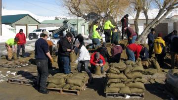 Students filling and stacking sandbags.