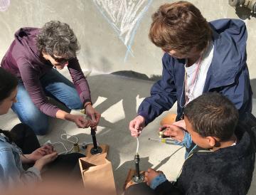 Peggy (center left) building lamps with After School Buddies program. 