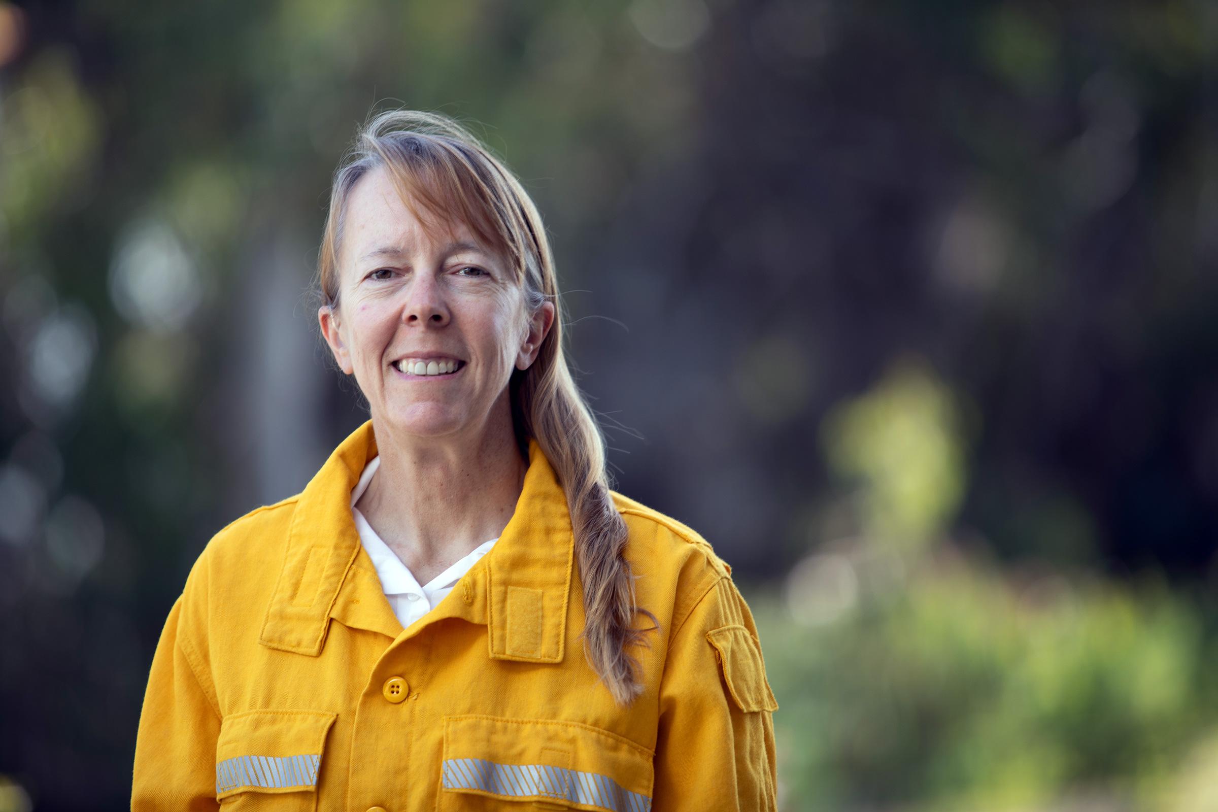 Woman standing for portrait with long yellow fire shirt on
