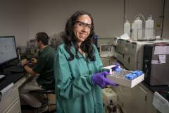 A scientist holding a tray of samples in a laboratory. 