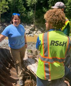 Image shows a woman and two men in high-visibility clothing standing by the I-40 construction site.