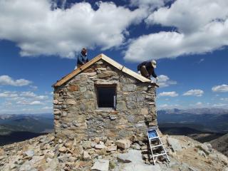 Two volunteers working on a cabin