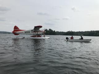 A seaplane being towed by a light aluminum boat
