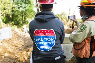 A picture of a Forest Service employee and a SalmonSuperHwy worker looking at their project work.