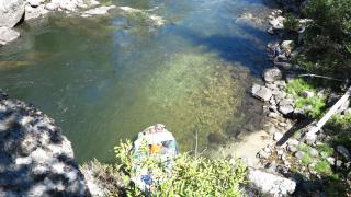 A picture of the river from up above looking down at a raft and the river's water.