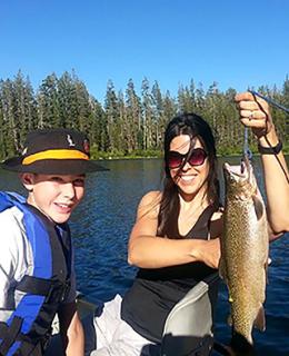 Image of a family in a boat with one person holding a fish.